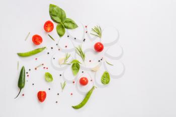 Fresh herbs with vegetables and spices on light background�
