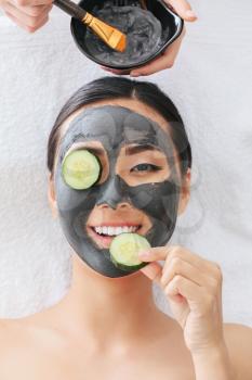 Beautiful Asian woman undergoing treatment with facial mask in beauty salon�