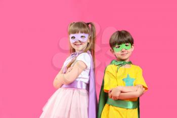 Cute little children dressed as superheroes on color background�