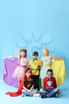 Cute little children dressed as superheroes on color background�