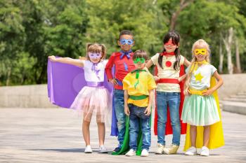 Cute little children dressed as superheroes outdoors�