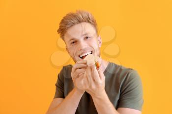 Man eating tasty taco on color background�