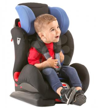 Little boy buckled in car seat on white background�