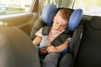 Sleeping baby boy buckled in car seat�