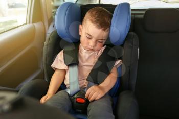 Sleeping baby boy buckled in car seat�