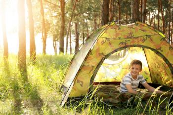 Little boy in camping tent on summer day�