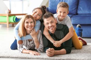 Happy couple with little adopted children at home�