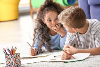 Happy adopted children drawing pictures in their new home�