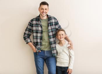 Happy man with little adopted boy on white background�