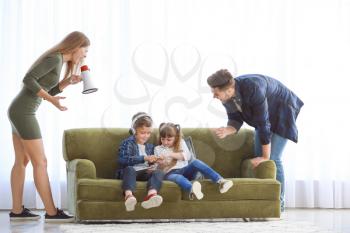 Parents scolding children with addiction to modern technologies at home�