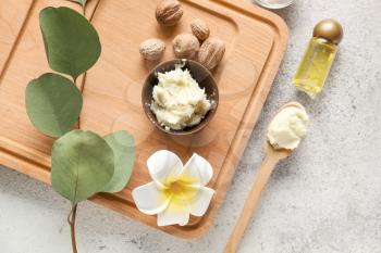 Shea butter with essential oil on light background�