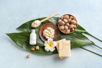 Shea butter with soap and cream on color background�