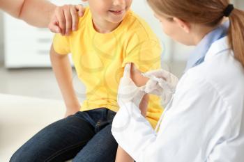 Doctor vaccinating little boy in clinic�