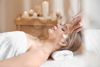 Beautiful young woman receiving massage in spa salon�