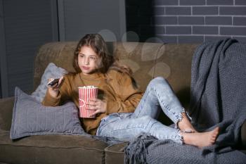 Teenage girl watching TV at night�