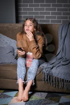 Emotional teenage girl watching TV at night�