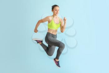 Running sporty woman on light color background�