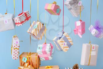Creative Christmas calendar with gift boxes on color background�