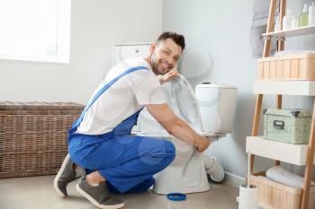 Plumber installing toilet in restroom�