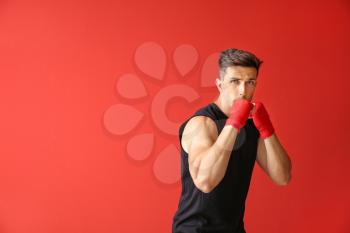 Sporty male boxer on color background�