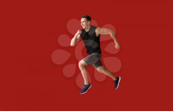 Running young man on color background�