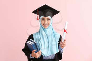 Muslim female graduate with diploma on color background�