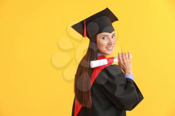 Female graduate with diploma on color background�