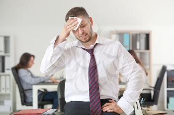 Businessman having panic attack in office�