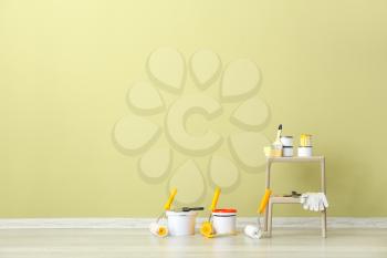 Paints with supplies near wall in room�