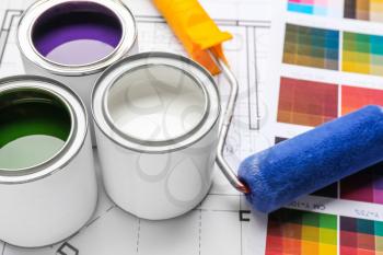 Cans of paint with roller and palette samples�