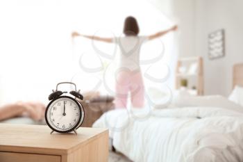 Alarm clock on table in bedroom of young woman�