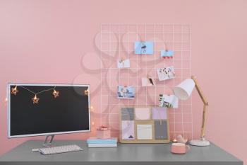 Workplace with mood board and computer in modern room�