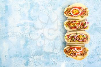 Stand with tasty fresh tacos on color background�