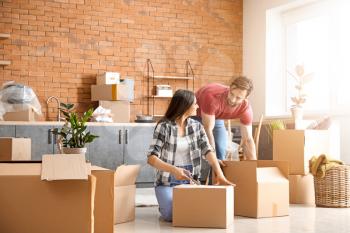 Young couple unpacking things after moving into new house�