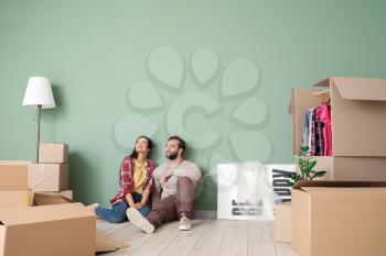 Happy young couple with cardboard boxes in their new house�
