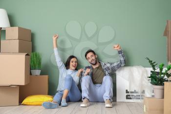 Happy young couple with cardboard boxes after moving into new house�