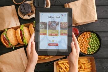 Woman with tablet computer ordering food online�
