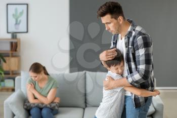 Man calming his son after family quarrel at home�