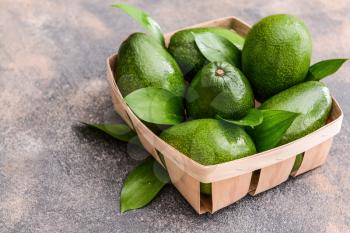 Box with fresh ripe avocados on grey background�