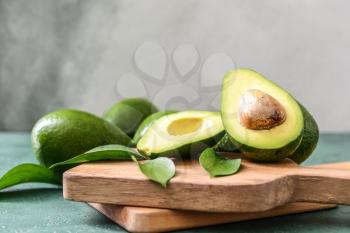 Boards with fresh ripe avocados on table 