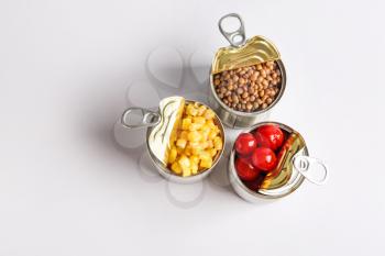Tin cans with different food on light background�