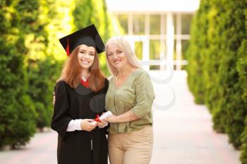Happy young woman with her mother on graduation day�