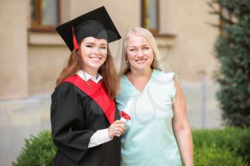Happy young woman with her mother on graduation day�