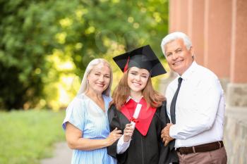 Happy young woman with her parents on graduation day�