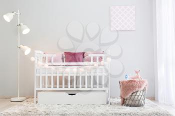 Interior of light modern baby room with crib�