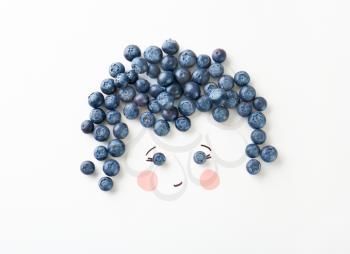 Cute face made of ripe blueberry on white background�