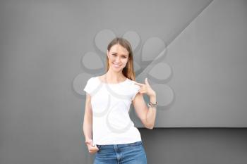 Woman in stylish t-shirt near grey wall�