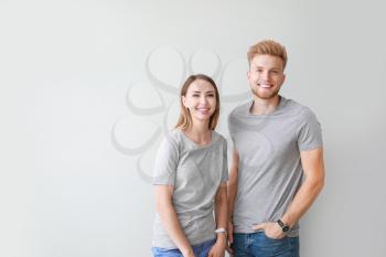 Couple in stylish t-shirts on light background�
