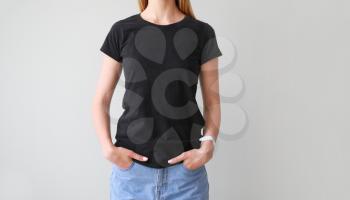Woman in stylish t-shirt on light background�