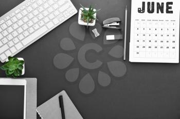 Composition with stationery, calendar and computer keyboard on dark background�